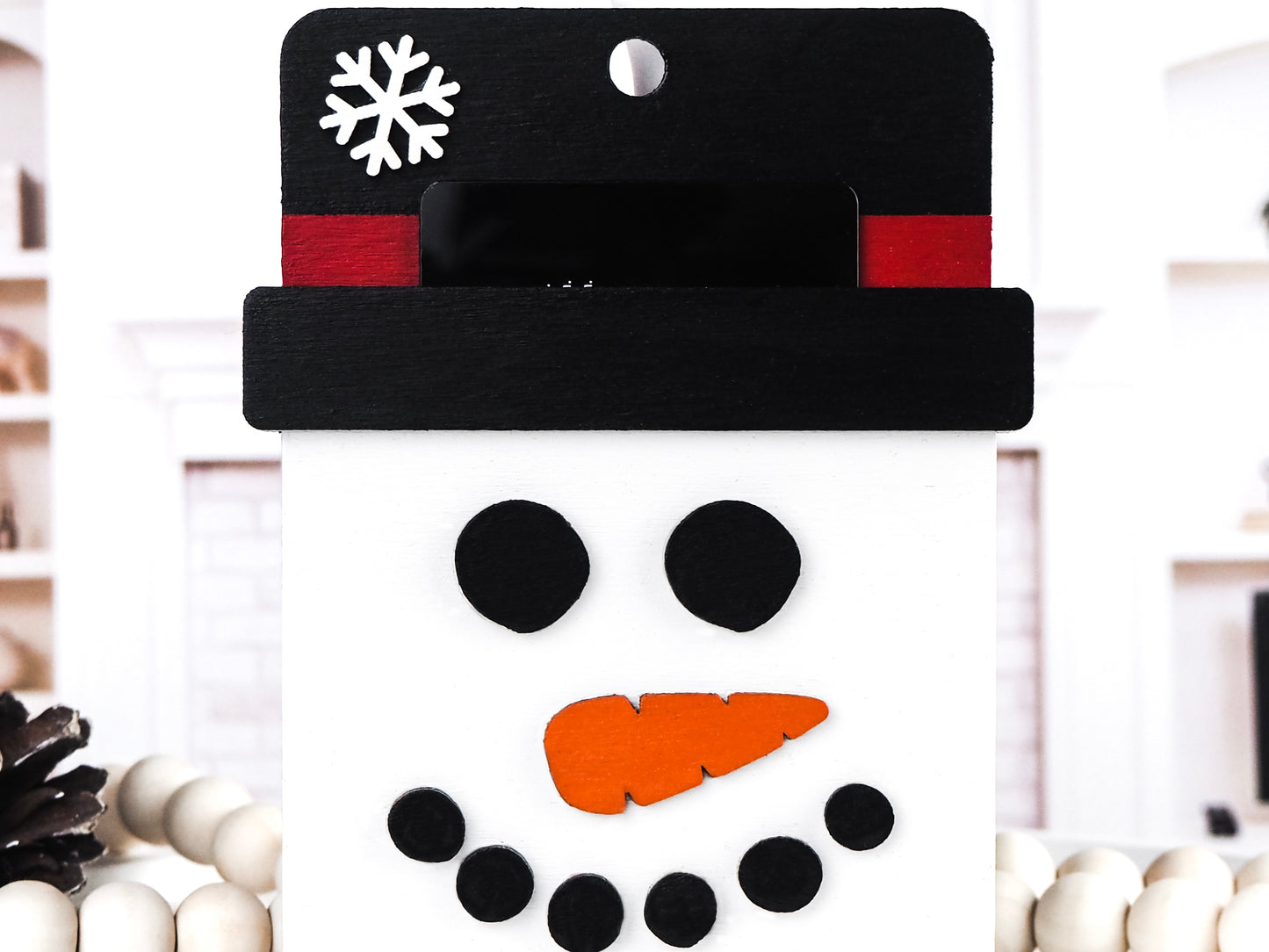 Handcrafted wooden Snowman Gift Card Ornament featuring a jolly snowman face with a black top hat, red band, and carrot nose, perfect for holding gift cards and adding festive charm to holiday décor.