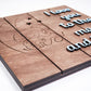 Close-up angled view of a wooden sign engraved with elephants under a crescent moon and stars, with raised blue lettering reading I love you to the moon and back.