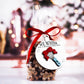 Clear bag of gingerbread cookies tied with a red ribbon and a round ornament featuring a raised whisk design with a red bow. The white ornament reads, "We Whisk You a Merry Christmas" with small stars around the whisk.