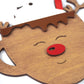 Close-up of a reindeer-themed mug ornament, featuring carved wooden antlers, a red nose, and a white whipped cream design at the top.