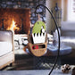 Wooden "Daily Elf Report" ornament with a green elf hat and a slider to choose between "Naughty" or "Nice." The ornament hangs in front of a cozy fireplace, creating a warm holiday atmosphere.