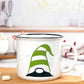 White speckled ceramic campfire mug with a black rim. The mug features a whimsical gnome design, with the gnome wearing a green and white striped hat that covers its eyes, with only the black nose and part of the beard visible.