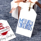 Two white rectangular Christmas gift tags. The first tag features a red gnome holding a sign that says No Peaking! with Merry Christmas written in black script at the bottom. The second tag has the phrase Merry Christmas written in a whimsical blue and gray font.