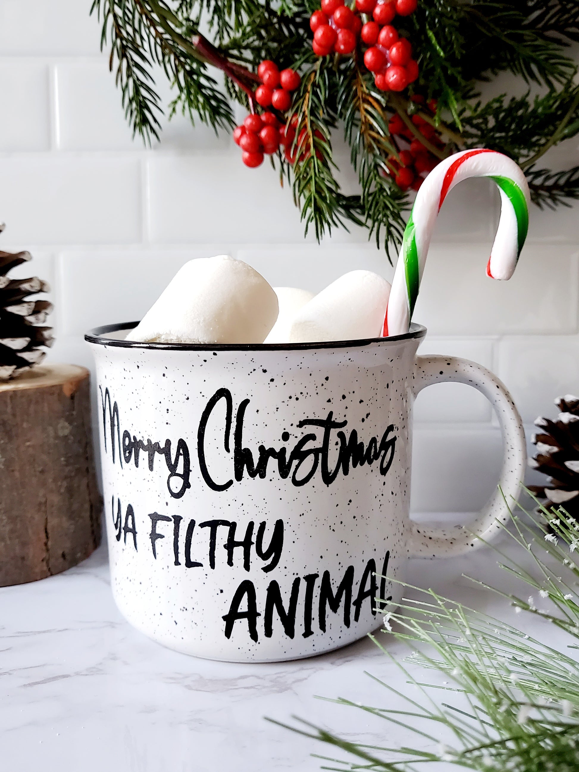 Campfire white ceramic mug with speckles and a black halo around the rim. The words Merry Christmas Ya Filthy Animal are hand-painted in black is on one side. The Merry Christmas Ya Filthy Animal is hand-painted by Snuggle Up Co.