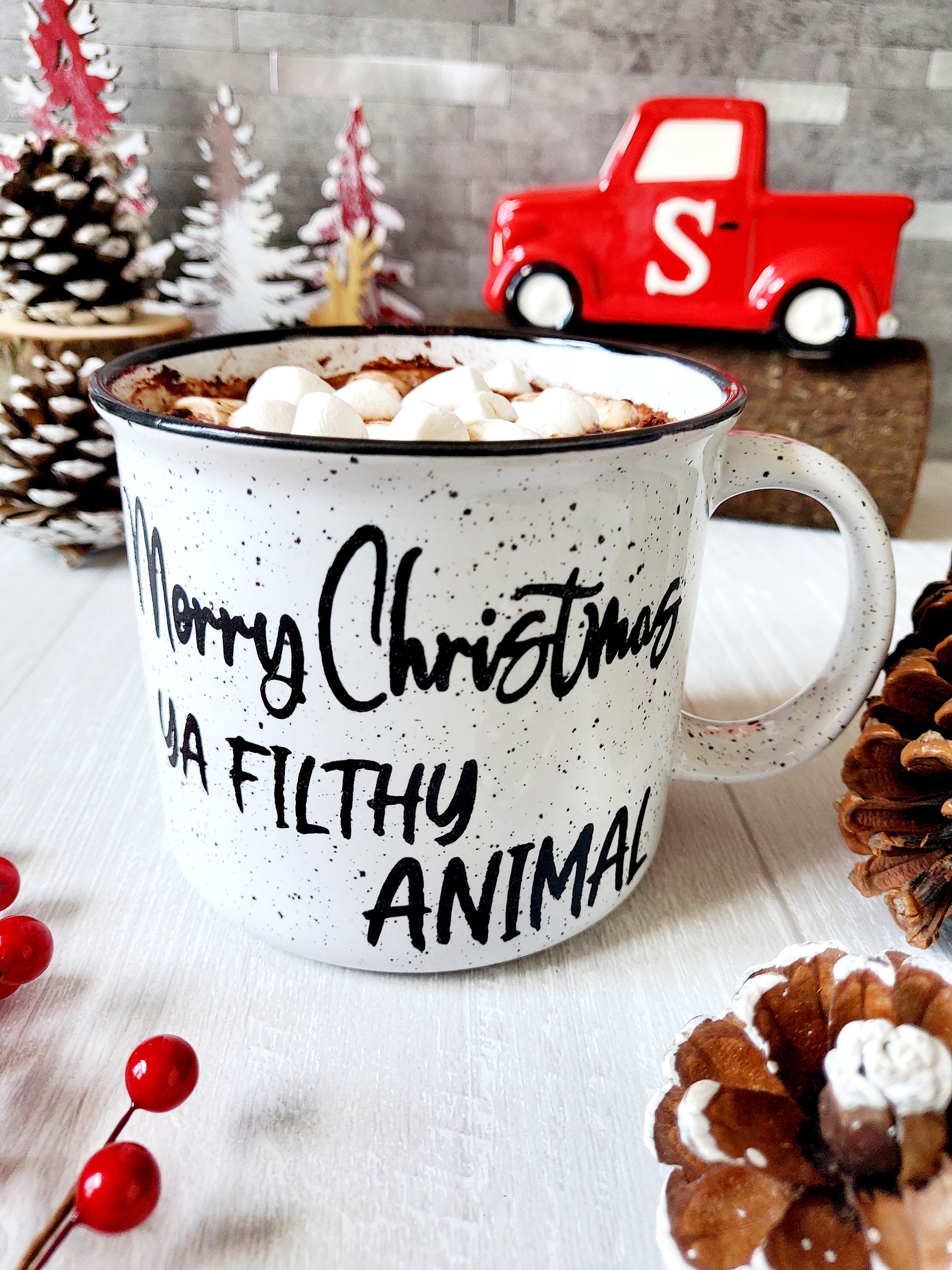 Campfire white ceramic mug with speckles and a black halo around the rim. The words Merry Christmas Ya Filthy Animal are hand-painted in black is on one side. The Merry Christmas Ya Filthy Animal is hand-painted by Snuggle Up Co.