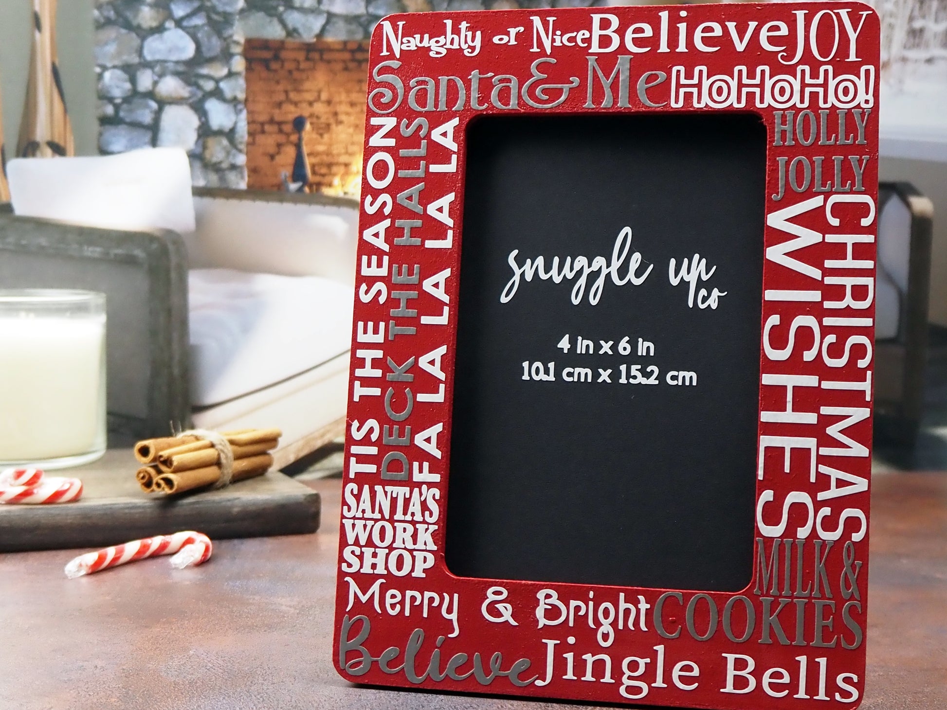 Deep red 4-inch by 6-inch picture frame. In silver and white writing, words are displayed on the frame; Santa & Me, Merry & Bright, Jingle Bells and a few more Christmas phrases. Handmade by Snuggle Up Co